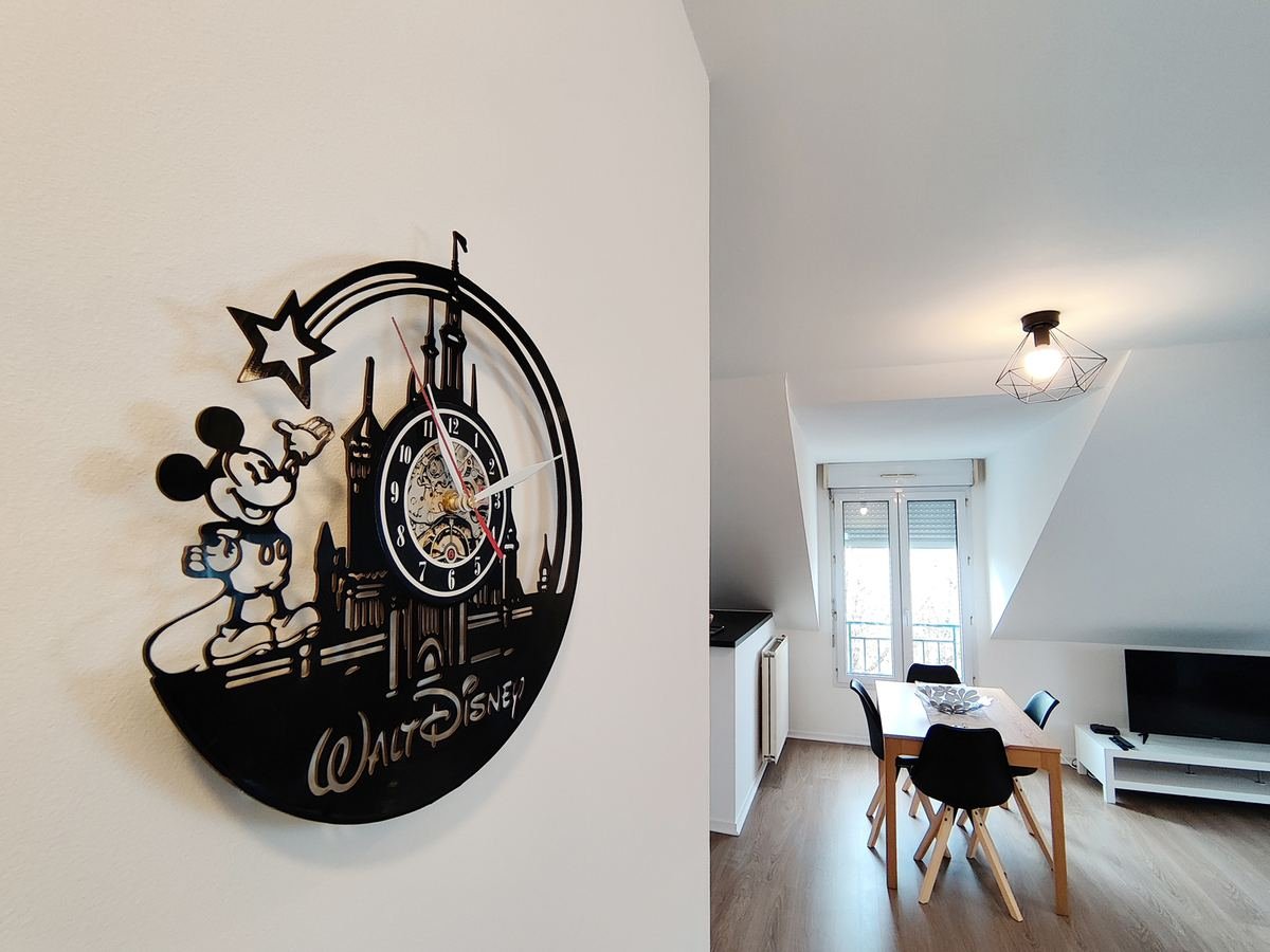 Horloge murale Mickey et vue sur le coin repas ouvert vers la fenêtre du séjour