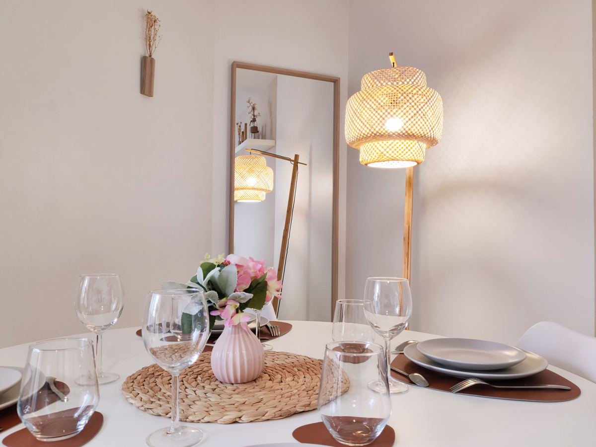 Coin repas dressé pour deux, avec miroir et suspension en rotin