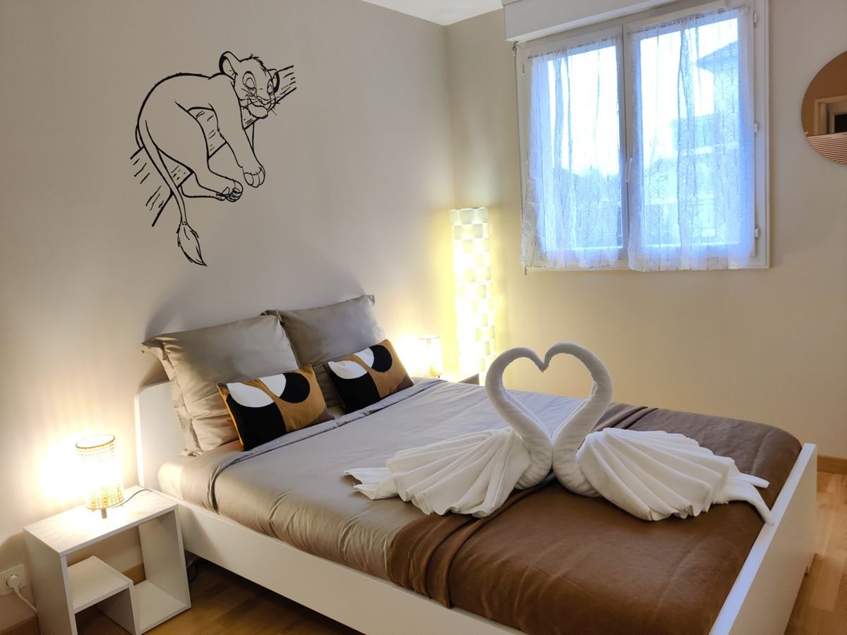 Chambre de CasaSimba avec lit double, serviettes pliées en cygnes et sticker mural Simba