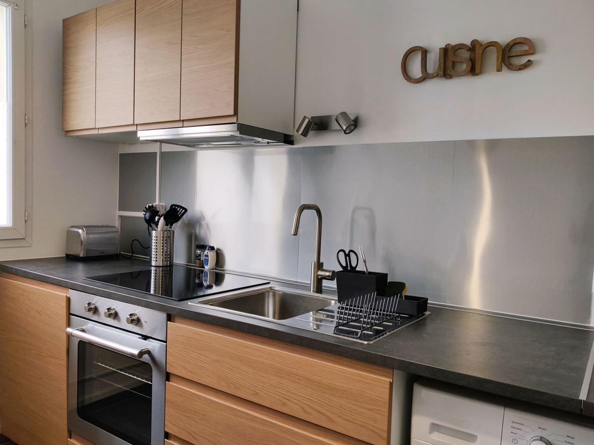 Cuisine équipée en bois avec four, plaque à induction, évier et grille-pain