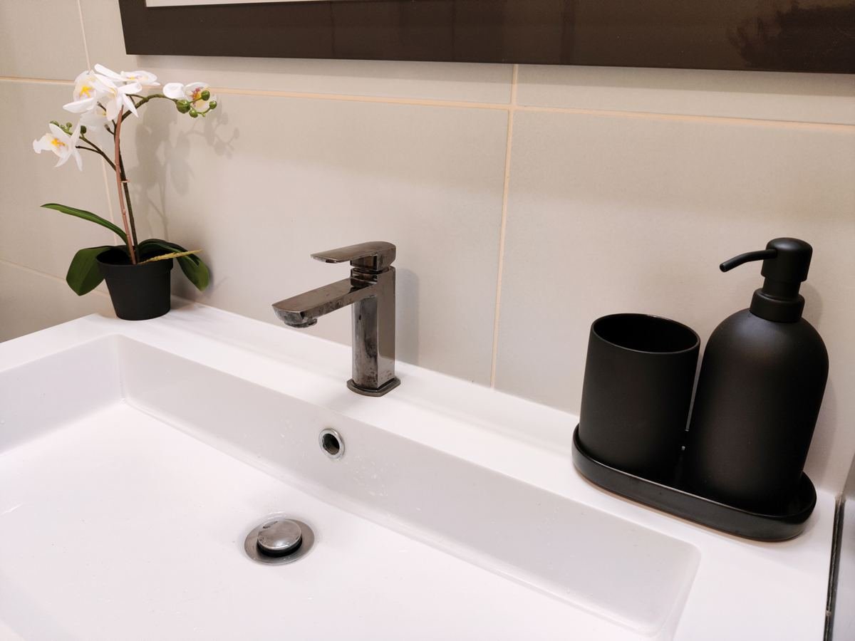 Vasque de la salle de bains avec distributeur de savon et orchidée